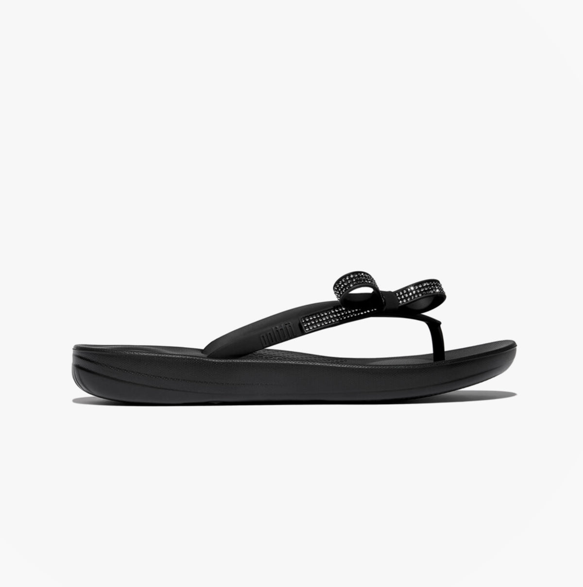 FitFlop iQUSHION GLITZ-BOW Ladies Flip Flops Black side view showcasing sleek design and comfortable TPR material.
