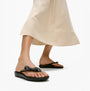 FitFlop iQUSHION GLITZ-BOW Ladies Flip Flops Black side view worn by model with a cream skirt
