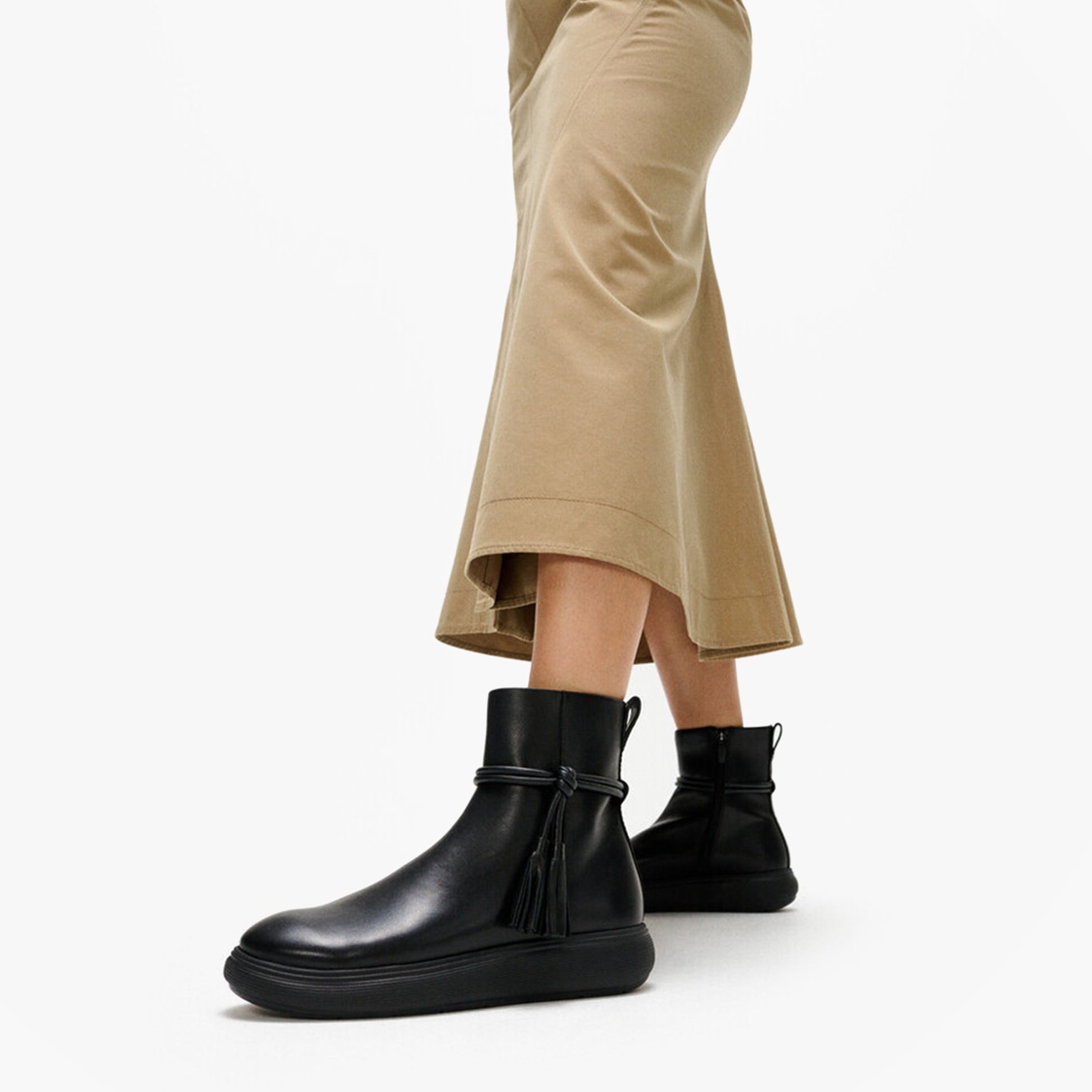 FitFlop iQ-COMFF TASSEL LEATHER Ladies Short Boots All Black side view on model wearing beige skirt