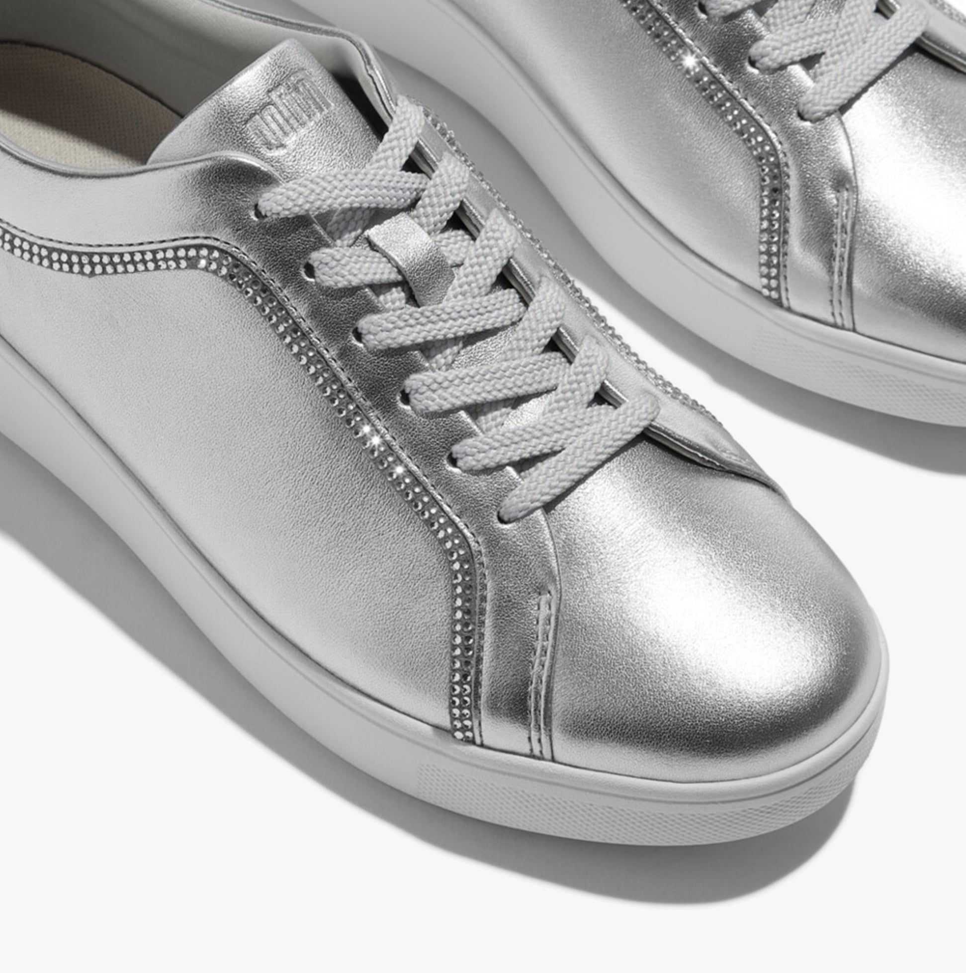 FitFlop RALLY CRYSTAL-TRIM LEATHER Womens Fashion Trainers Silver detail view with lace-up design and metallic shine.