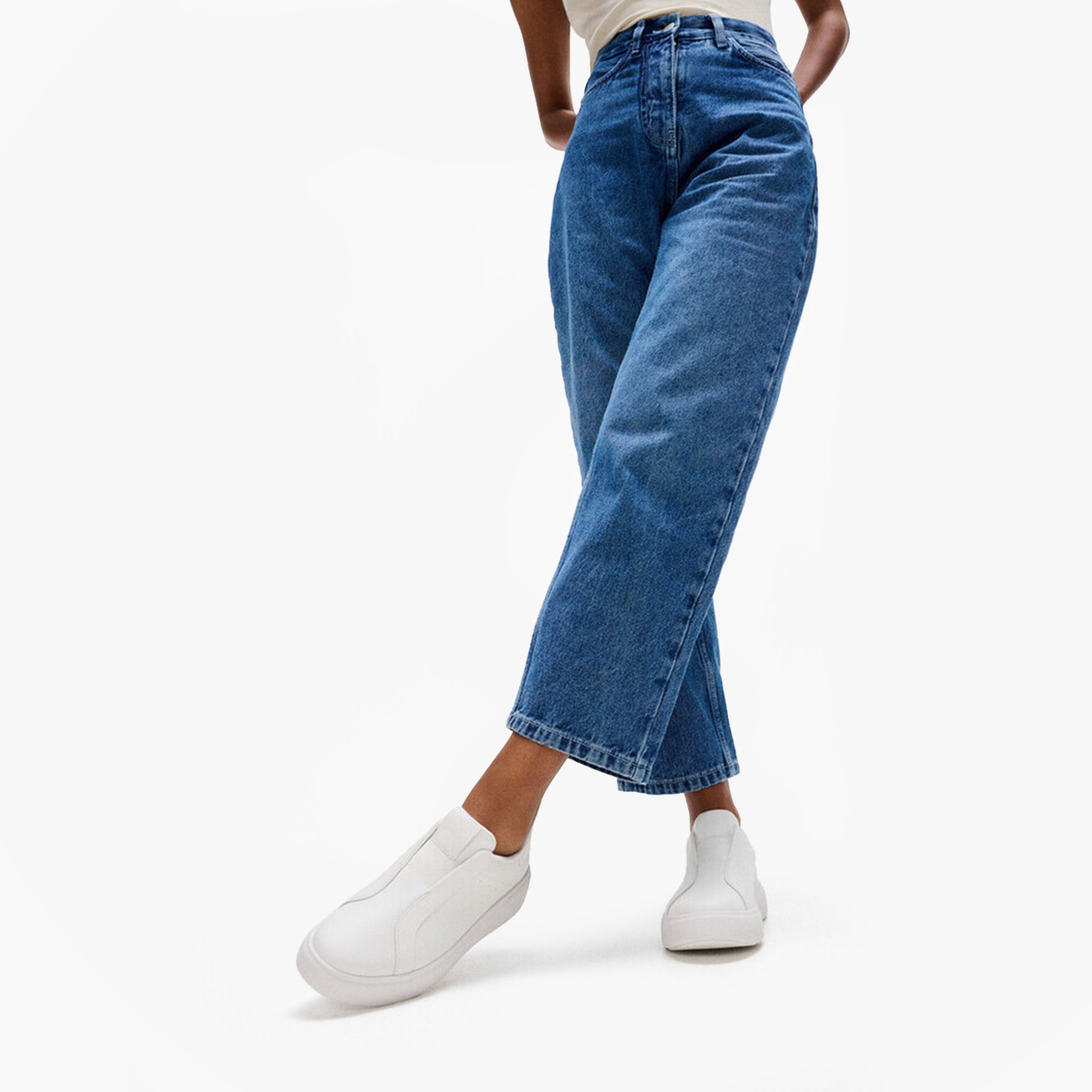 FitFlop 'Ready To Go' LEATHER LACELESS Ladies Sneakers Urban White worn with blue jeans, side view, stylish casual outfit.