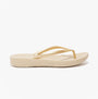 FitFlop IQUSHION Womens Flip Flops Gold side view showcasing lightweight comfort and flat sole design.