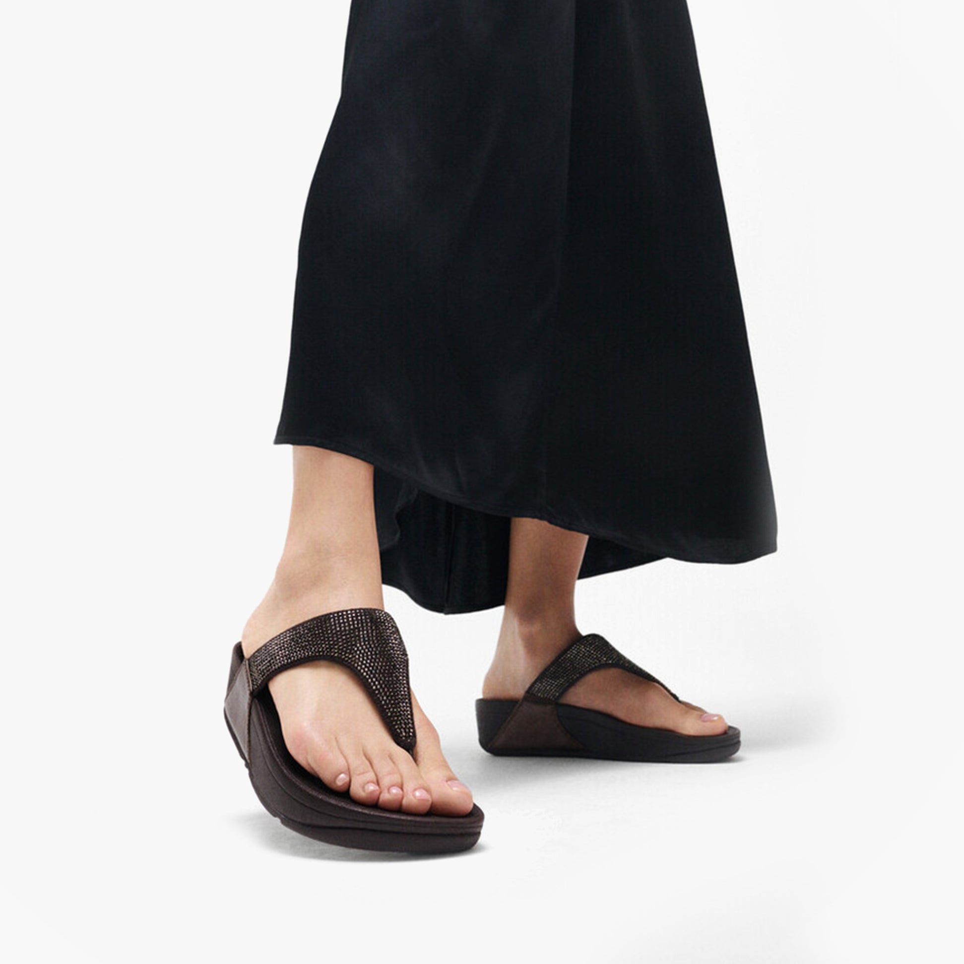 FitFlop LULU CRYSTAL EMBELLISHED Ladies Toe Post Sandals Metallic Chocolate Brown side view worn with black dress.