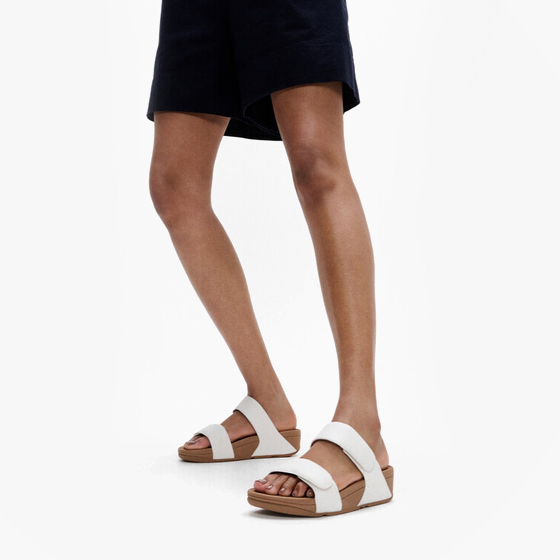 FitFlop LULU ADJUSTABLE Womens Slides Urban White side view on model's feet.