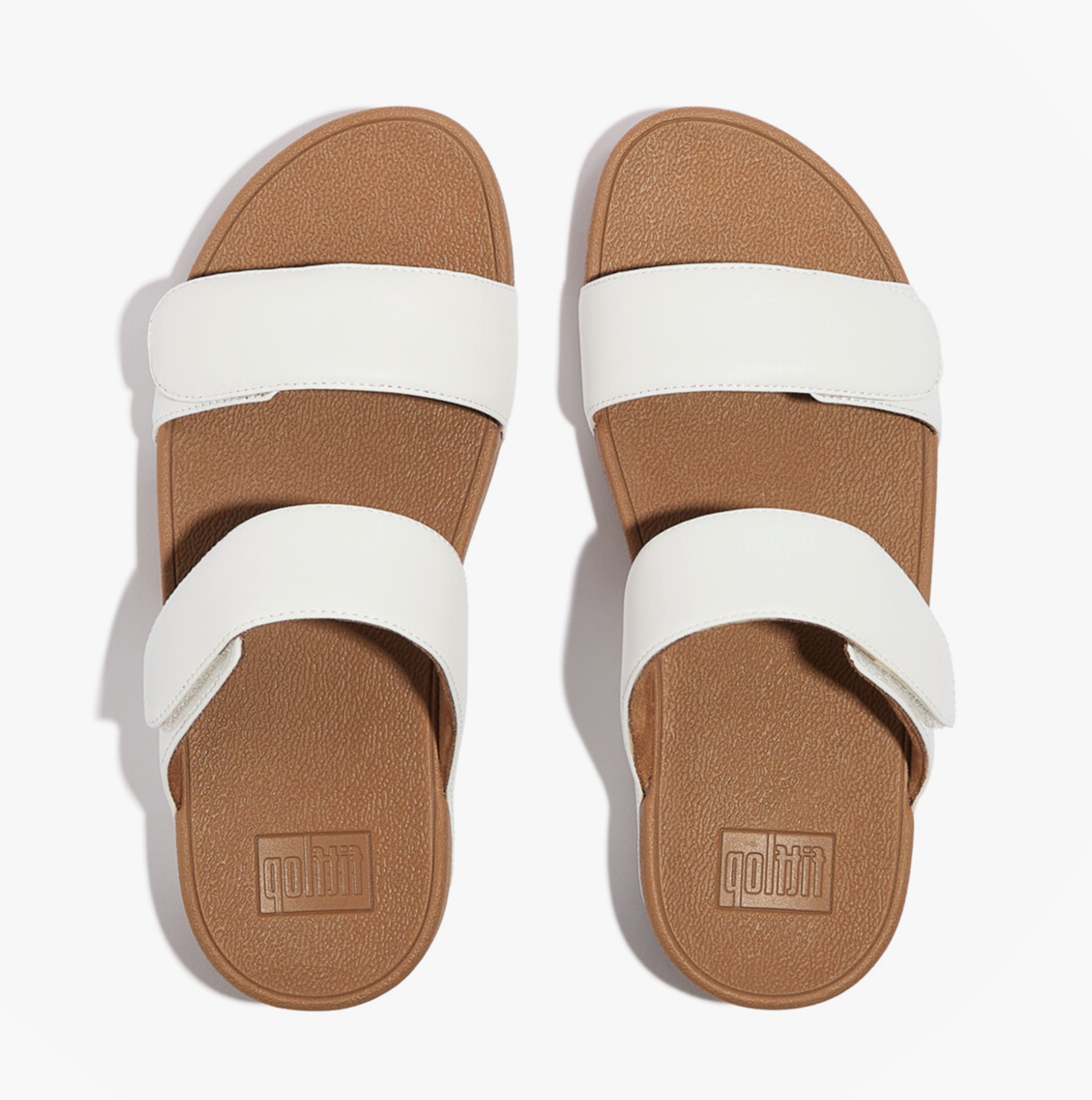 FitFlop LULU ADJUSTABLE Womens Slides Urban White top view showcasing dual white straps and brown sole.