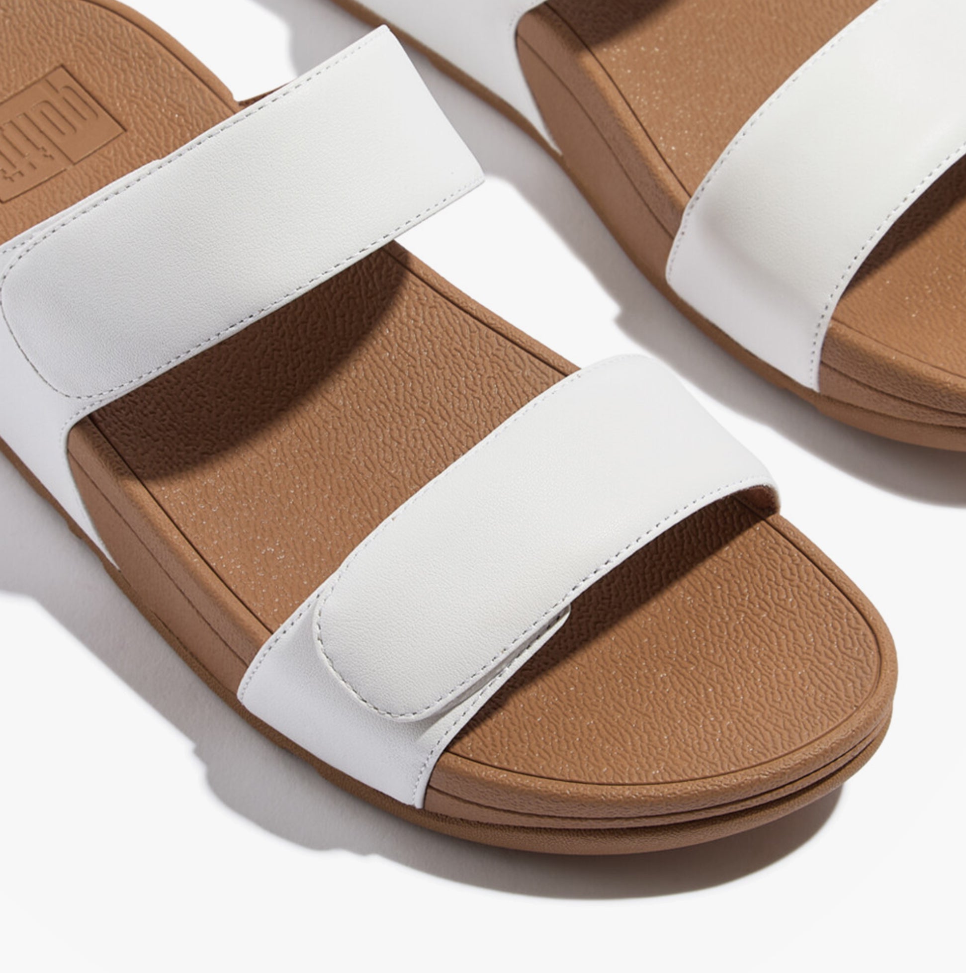 FitFlop LULU ADJUSTABLE Womens Slides Urban White top view showcasing the leather upper and rubber sole.