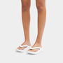FitFlop RELIEFF RECOVERY Womens Toe Post Sandals Urban White side view on model wearing white sandals, showcasing comfort and style.