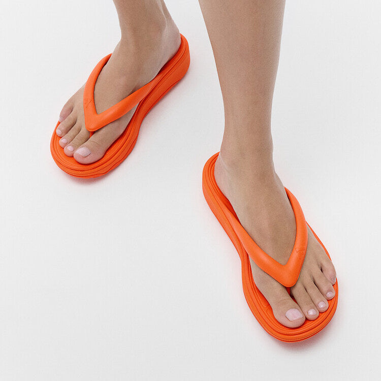 FitFlop RELIEFF RECOVERY Womens Toe Post Sandals Pop Orange side view on model's feet showcasing comfort and style.