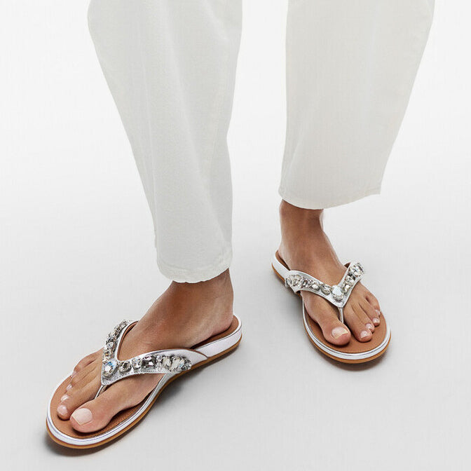 FitFlop GRACIE JEWEL-DELUXE Womens Flip Flops Silver side view worn on model's feet, showcasing comfort and stylish design.