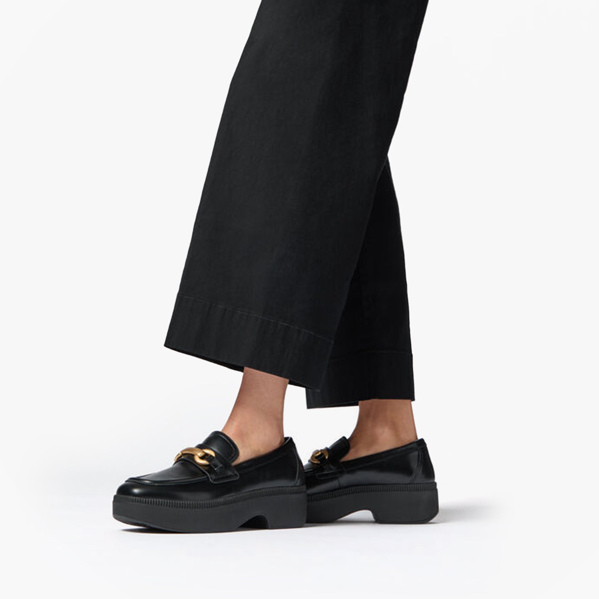 FitFlop F-LUMA CHUNKY SNAFFLE Womens Wedge Loafers Black, side view lifestyle image with outfit.