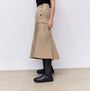 FitFlop F-MODE Womens Boots Black side view worn with a beige skirt, showcasing their sleek design and comfortable fit.