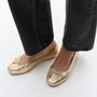 FitFlop DELICATO BOW SOFT Womens Ballet Flats Platino worn view with gold leather finish and bow detail.