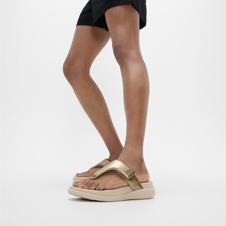 FitFlop F-MODE GO Womens Toe Post Sandals Platino side view on a model's foot, showcasing the stylish gold strap and platform sole.
