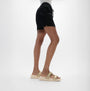 FitFlop F-MODE GO Womens Slides Platino side view worn with black shorts, featuring luxury leather and a comfortable slip-on design.