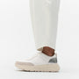 FitFlop F-MODE LEATHER Womens Trainers Urban White/Silver side view on model's foot with cream pants.