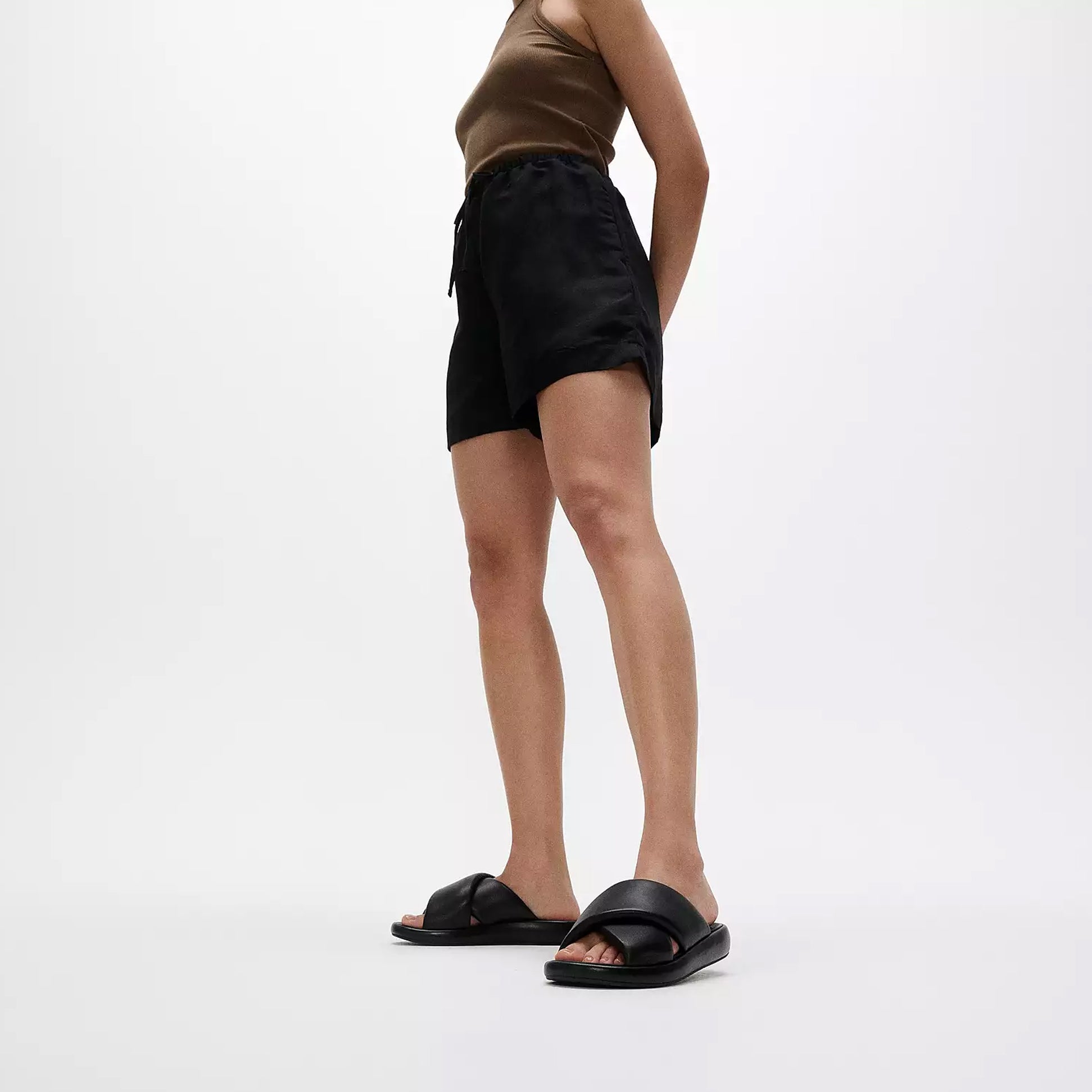 FitFlop iQUSHION D-LUXE Womens Slides All Black side view worn with black shorts and brown top