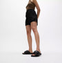 FitFlop iQUSHION D-LUXE Womens Slides All Black side view worn with black shorts and brown top