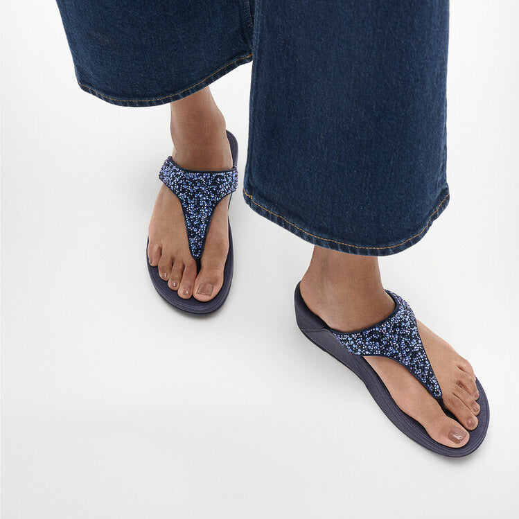 FitFlop LULU CRYSTAL-MIX Womens Toe Post Sandals Midnight Navy side view on model's feet with casual denim pants.