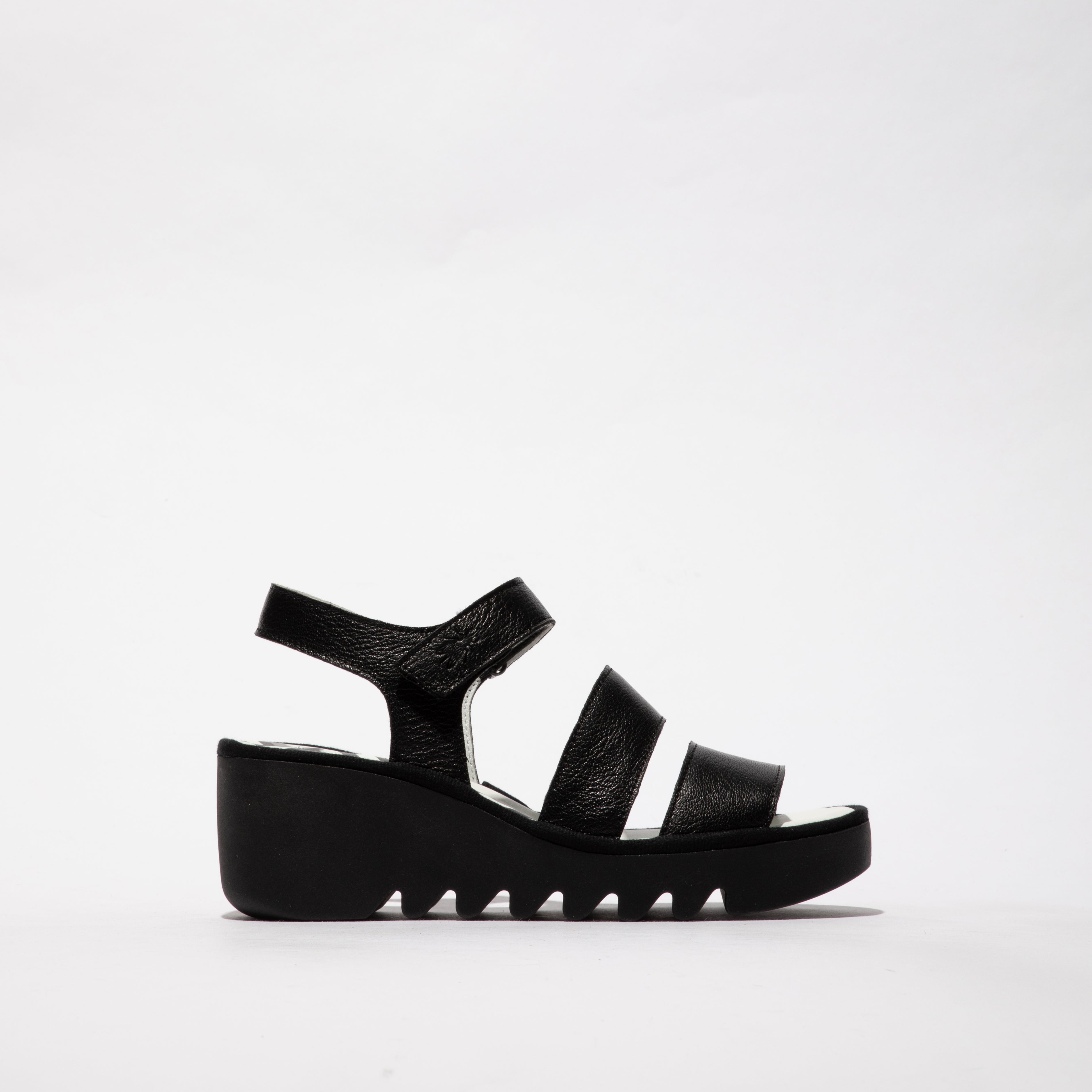 Fly London BEXY575FLY Womens Sandals Black side view, featuring leather upper, wedge heel, and touch fasten design.