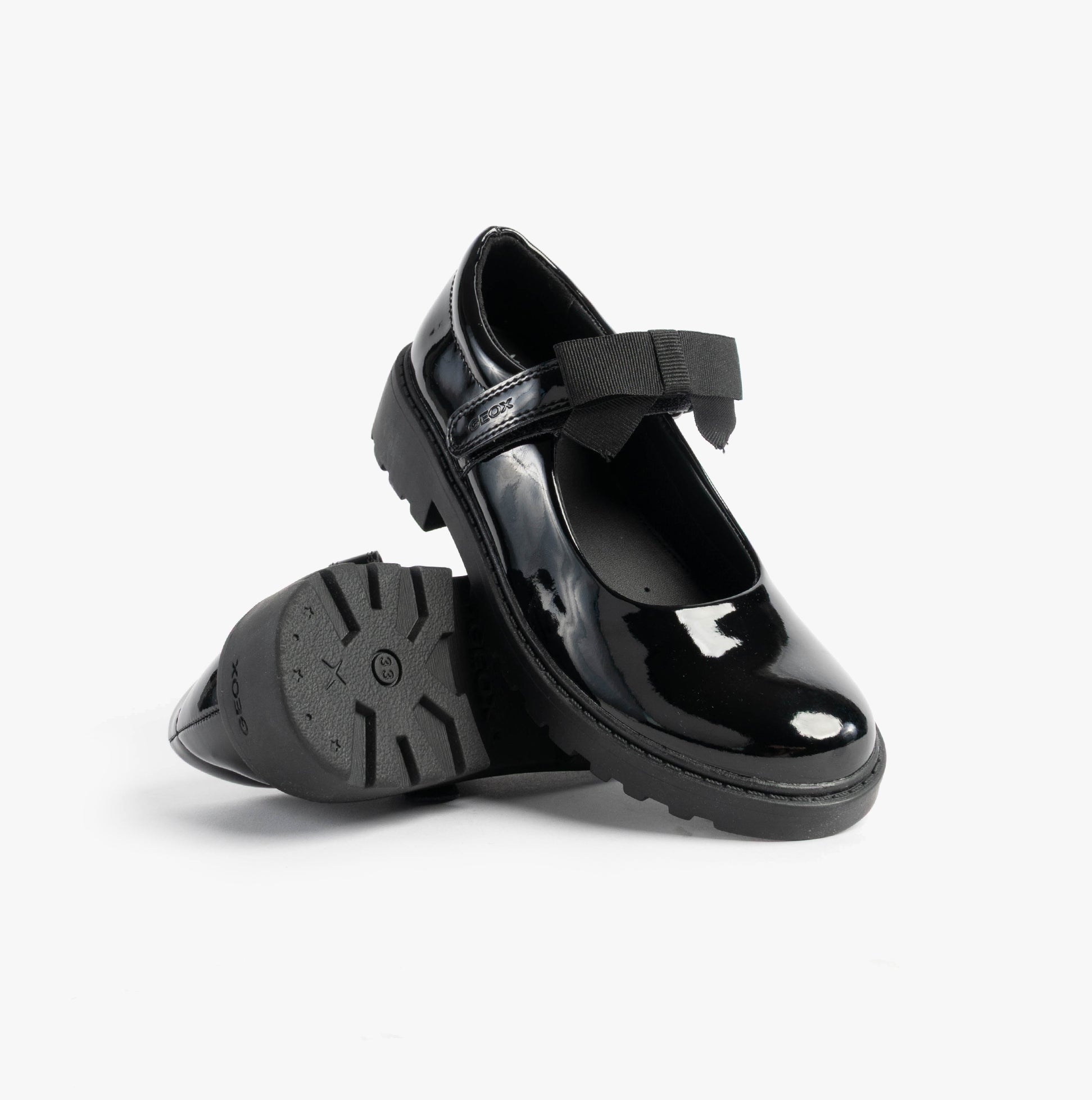GEOX J CASEY GIRL Girls Black side view of shiny patent leather school shoes with bow detail.