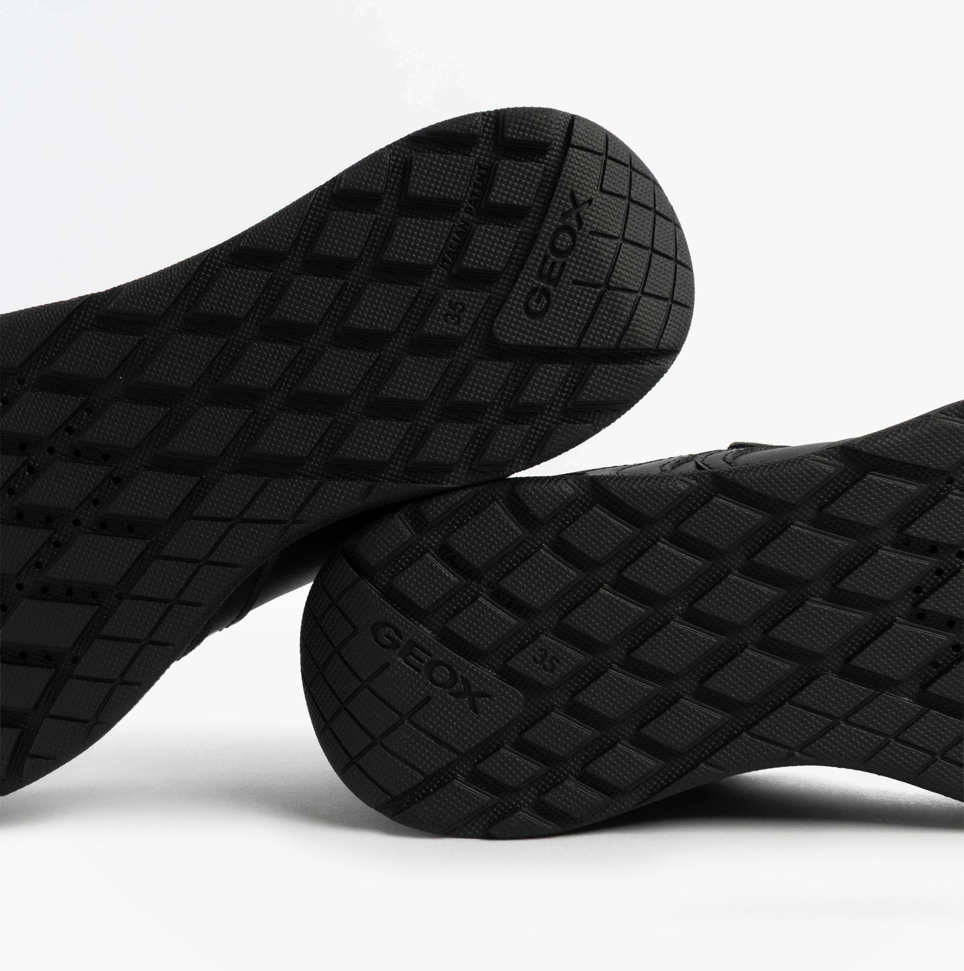 GEOX J RANN-E BOY Unisex Kids Touch Fasten Trainers Black sole view showcasing the textured grip and brand logo.