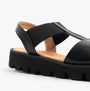 Heavenly Feet RITZ Womens Sandals Black close-up side view showcasing the synthetic upper, wedge heel, and slip-on design.