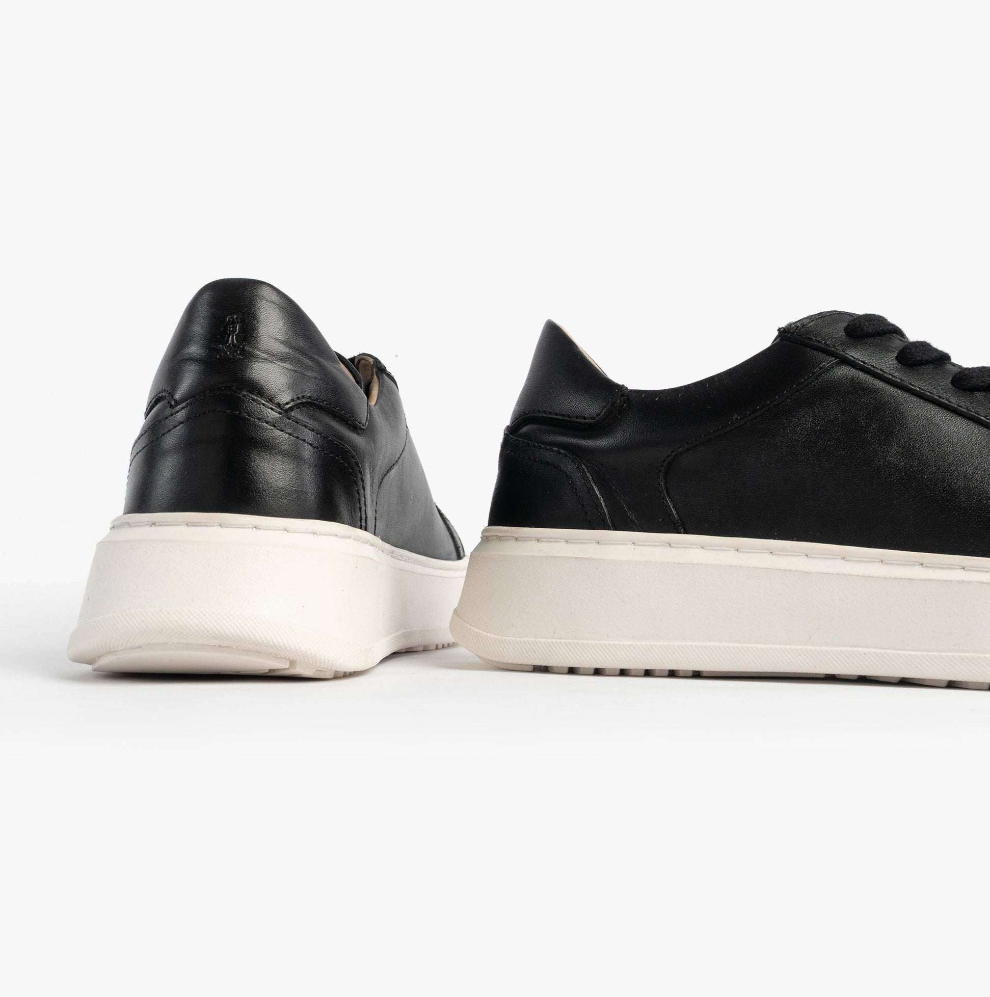 Hush Puppies CAMILLE Womens Trainers Black side view showing sleek leather upper and contrasting white sole.