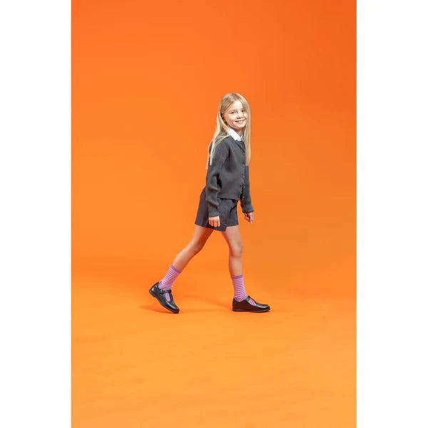 Hush Puppies BRITNEY Girls Leather School Shoes Black worn by a girl walking, side view with vibrant orange background.
