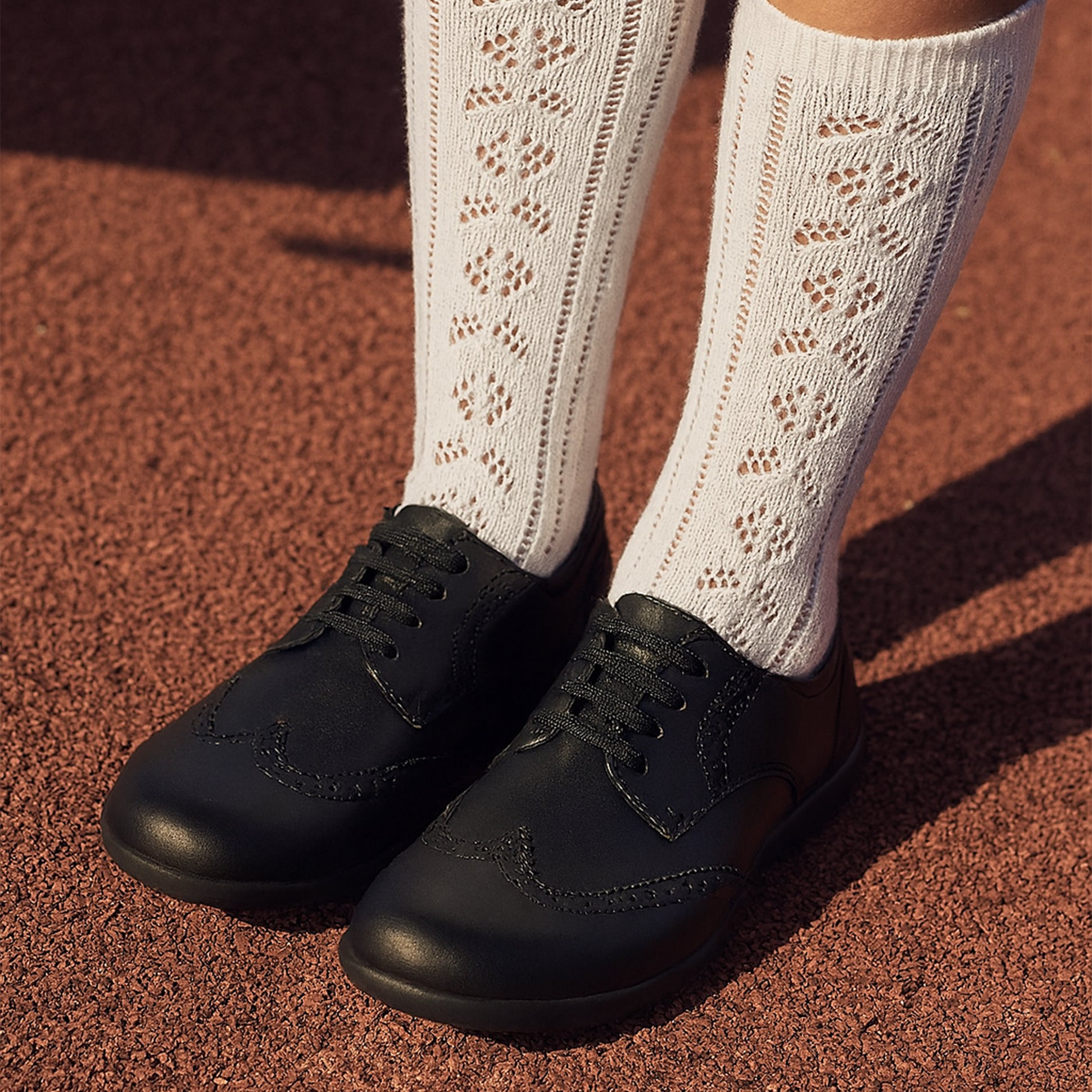 Hush Puppies BRIDGET Girls Leather School Shoes Black front view with white patterned socks.