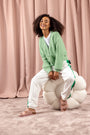 Hush Puppies JESSIE Ladies Slippers Light Pink, side view worn by a model seated on a large textured ball.