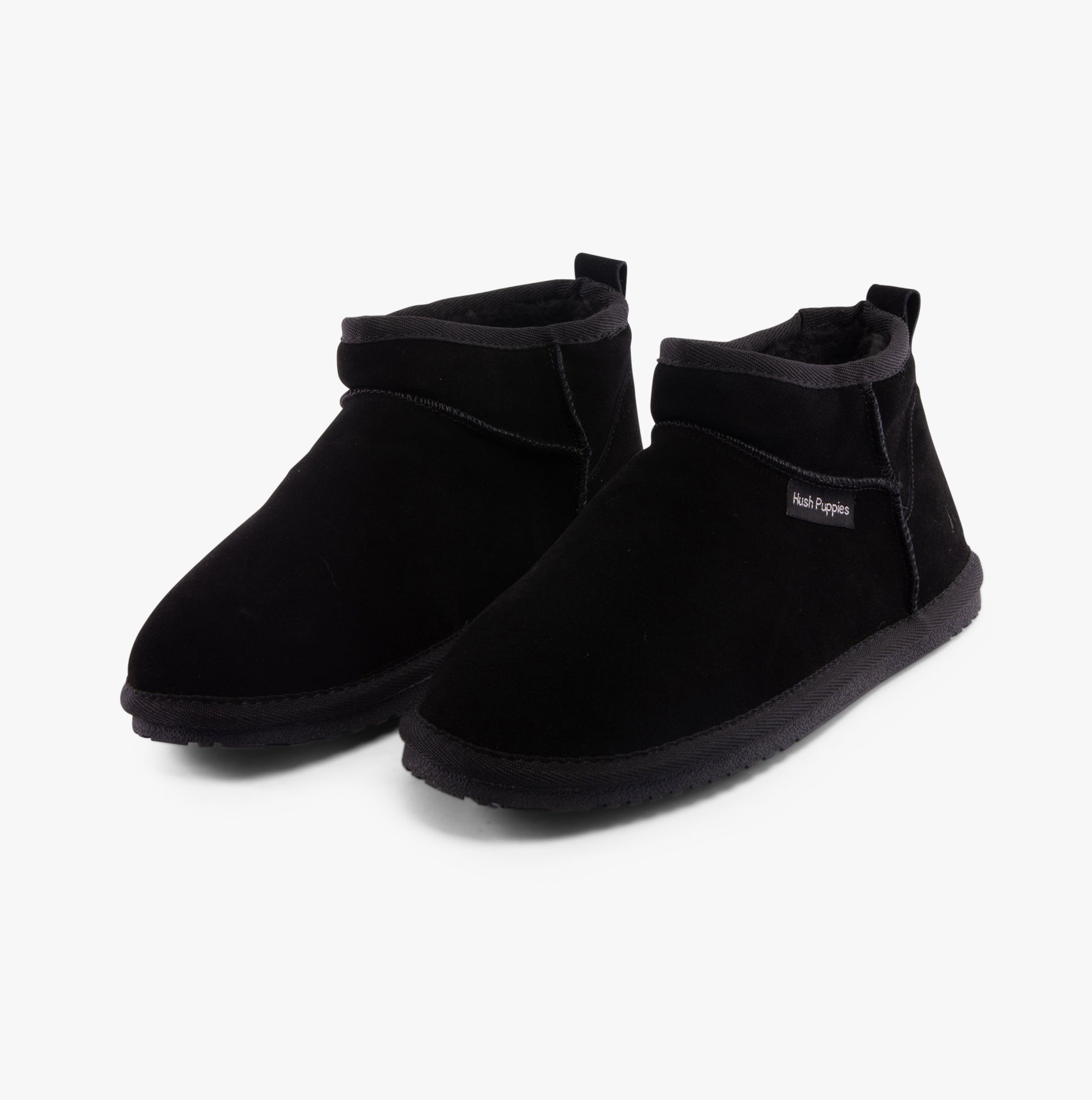 Hush Puppies ASHANTI Womens Slippers Black side view showing black suede slipper boots with faux fur lining.