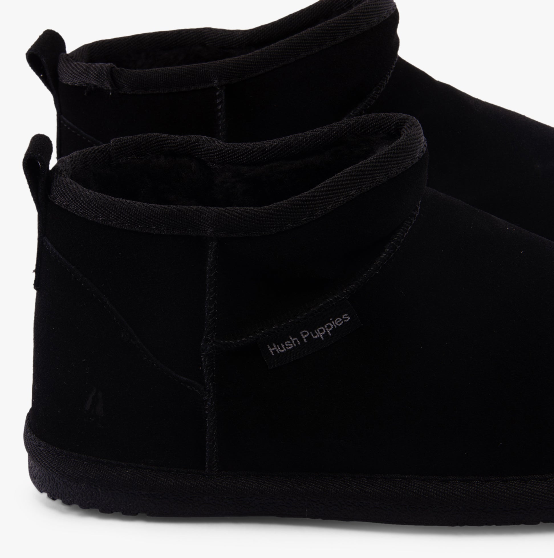 Hush Puppies ASHANTI Womens Slippers Black side view, showing suede upper and faux fur lining, perfect for comfort and warmth.