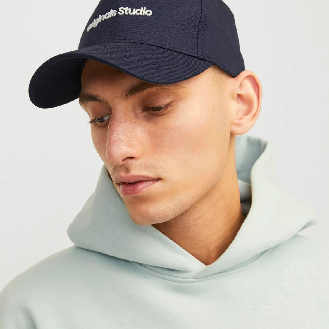 Jack & Jones VESTERBRO Mens Cap Sky Captain detail view worn by model with hoodie