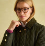 Joules ROSEWELL Womens Longline Quilted Showerproof Coat Green close-up view on model, showcasing diamond quilt pattern and funnel neck.
