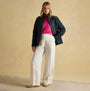 Joules BRAEMAR LUXE Womens Quilted Jacket Navy front view, model wearing quilted jacket with pink sweater and striped pants.