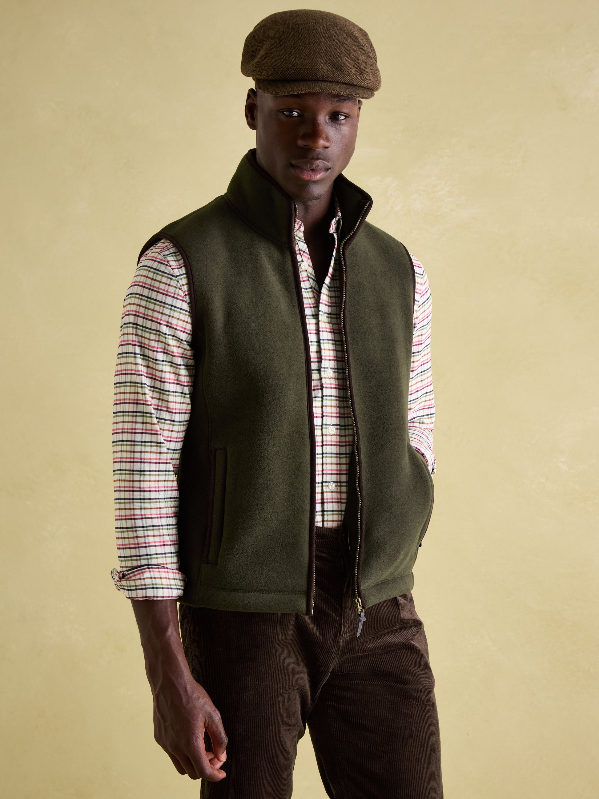Joules GREENFIELD Mens Gilet Green front view on model, showcasing zip closure, funnel neck, and stylish design.
