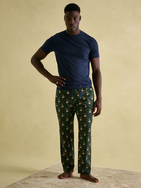 Joules DOZER Pyjama Bottoms Fenton Fox front view model wearing green pyjama bottoms with fox print, paired with a navy t-shirt.