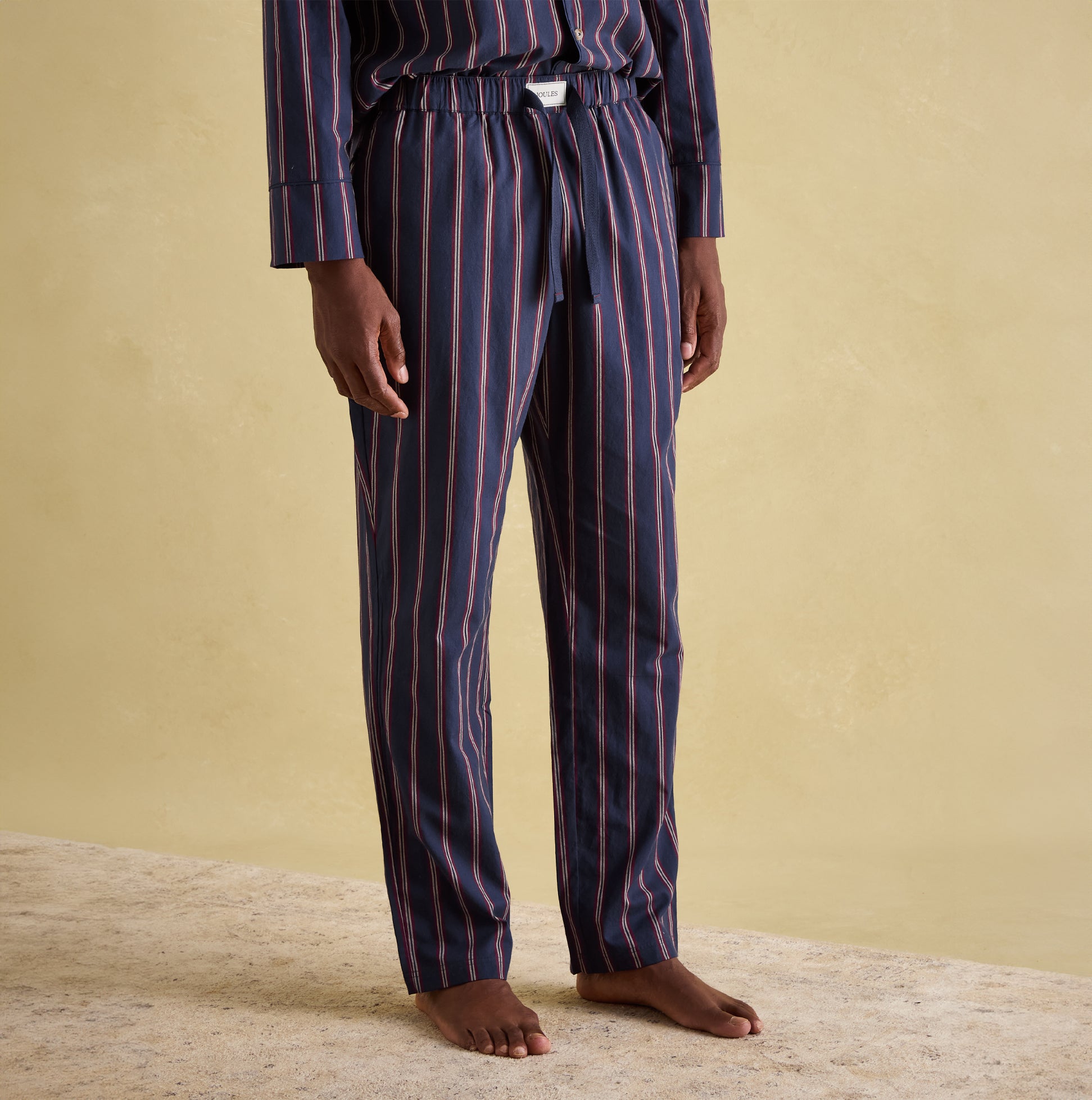 Joules HUGO Mens Pyjama Set Navy Stripe front view featuring long sleeves, elasticated waist, and piped trims.