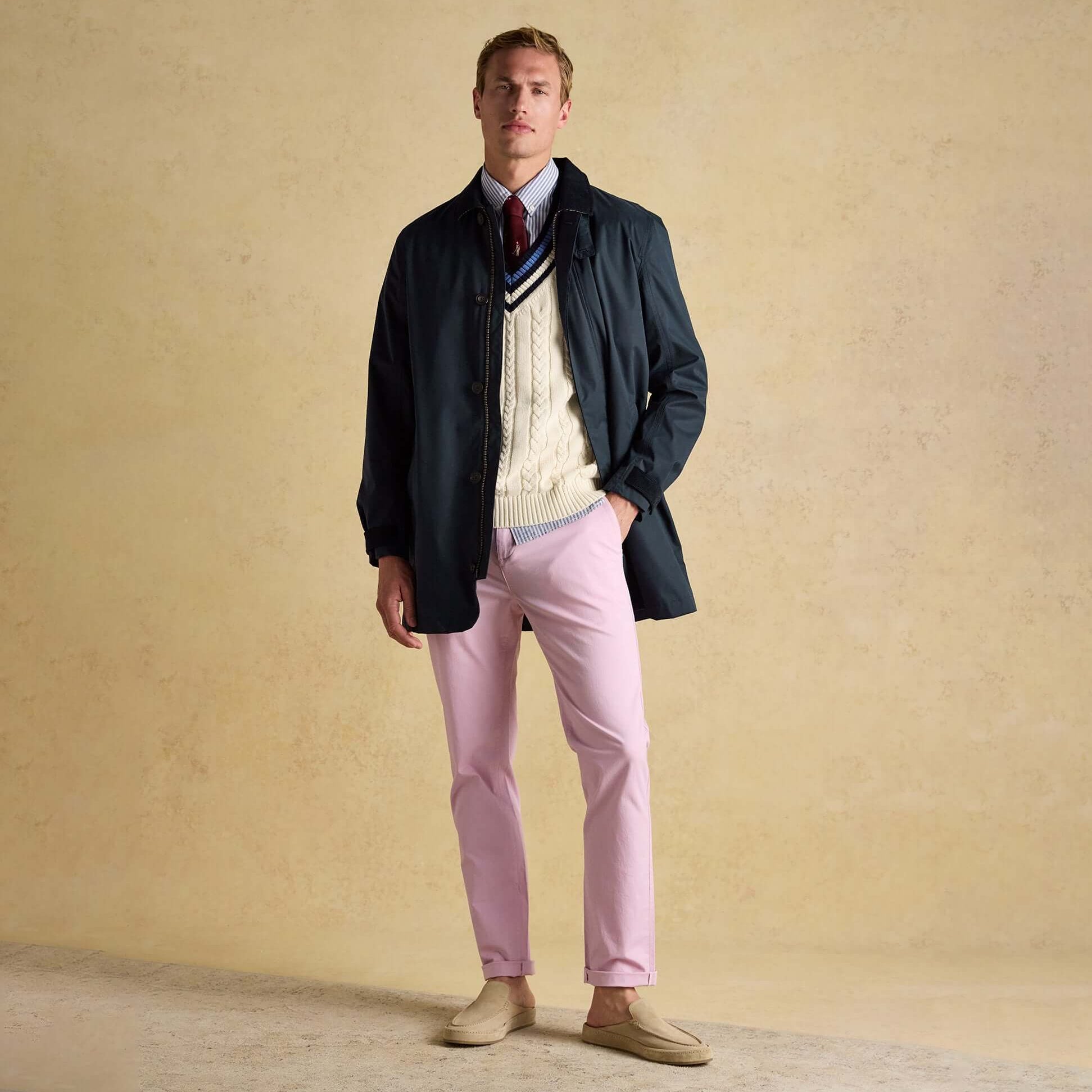 Joules SANDFORD Navy Blue Waterproof Raincoat Navy worn by a man in front view, styled with a sweater and pink pants.