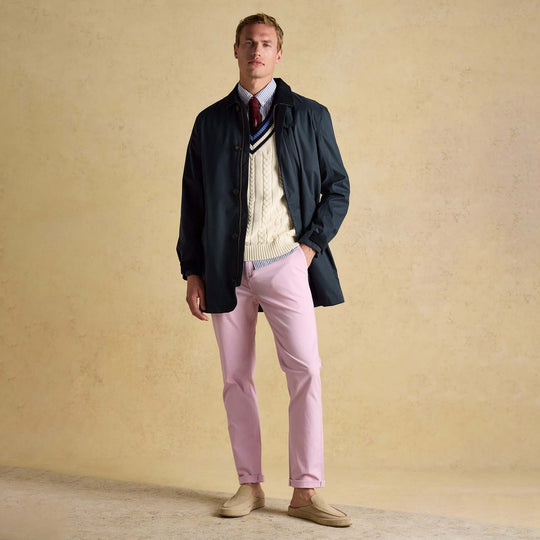Joules SANDFORD Navy Blue Waterproof Raincoat Navy worn by a man in front view, styled with a sweater and pink pants.