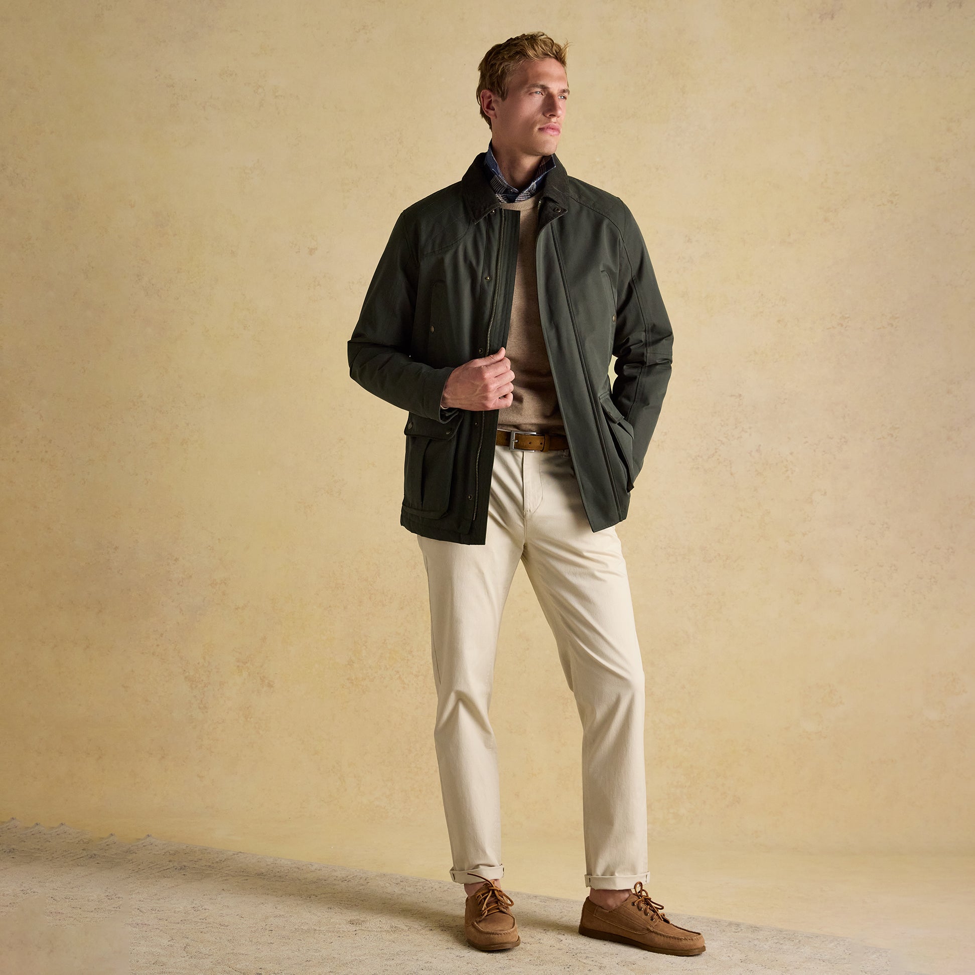 Joules FARLEIGH Mens Waterproof Midweight Country Coat Green front view, showcasing lifestyle wear with beige pants.