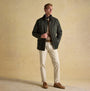 Joules FARLEIGH Mens Waterproof Midweight Country Coat Green front view, showcasing lifestyle wear with beige pants.