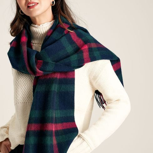 Joules LANGTREE Womens Scarf Navy Pink Check draped around model's shoulders, showcasing its woven texture and tasselled ends.