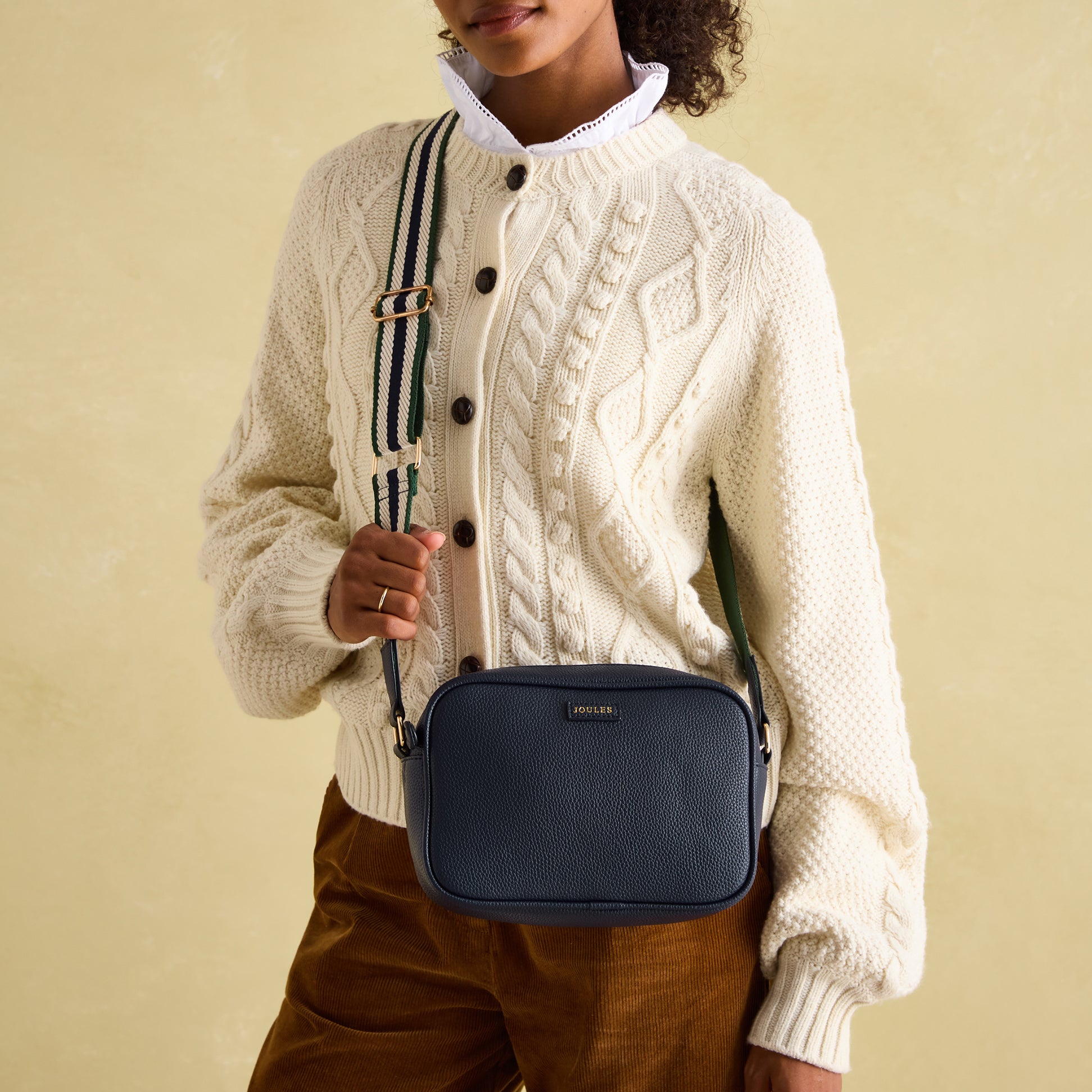Joules TRENT Womens Crossbody Bag Navy front view worn with a cream sweater and adjustable strap.