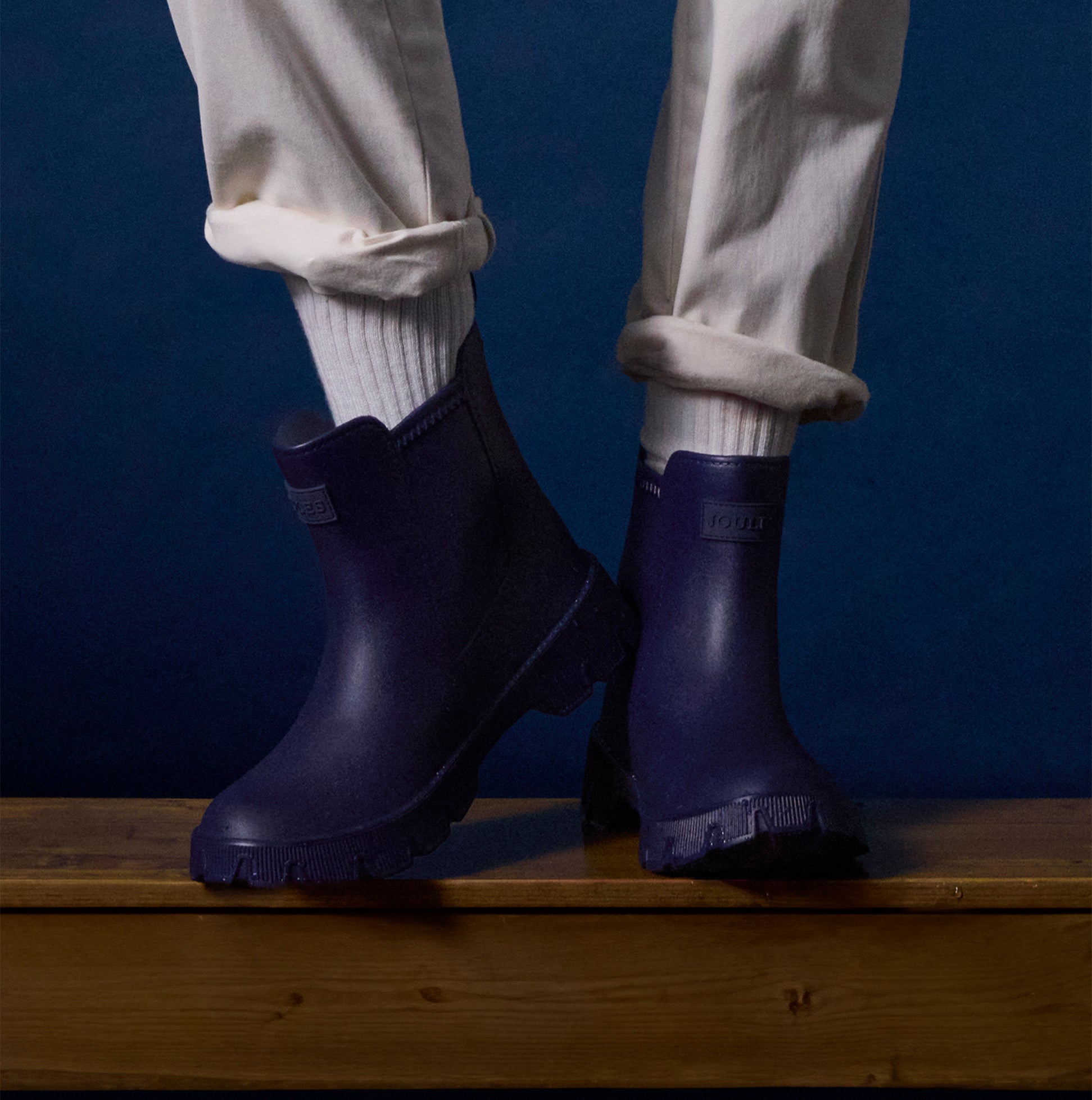 Joules RAINDANCE Lightweight Wellies Navy side view on a person standing on wooden surface with light clothing.