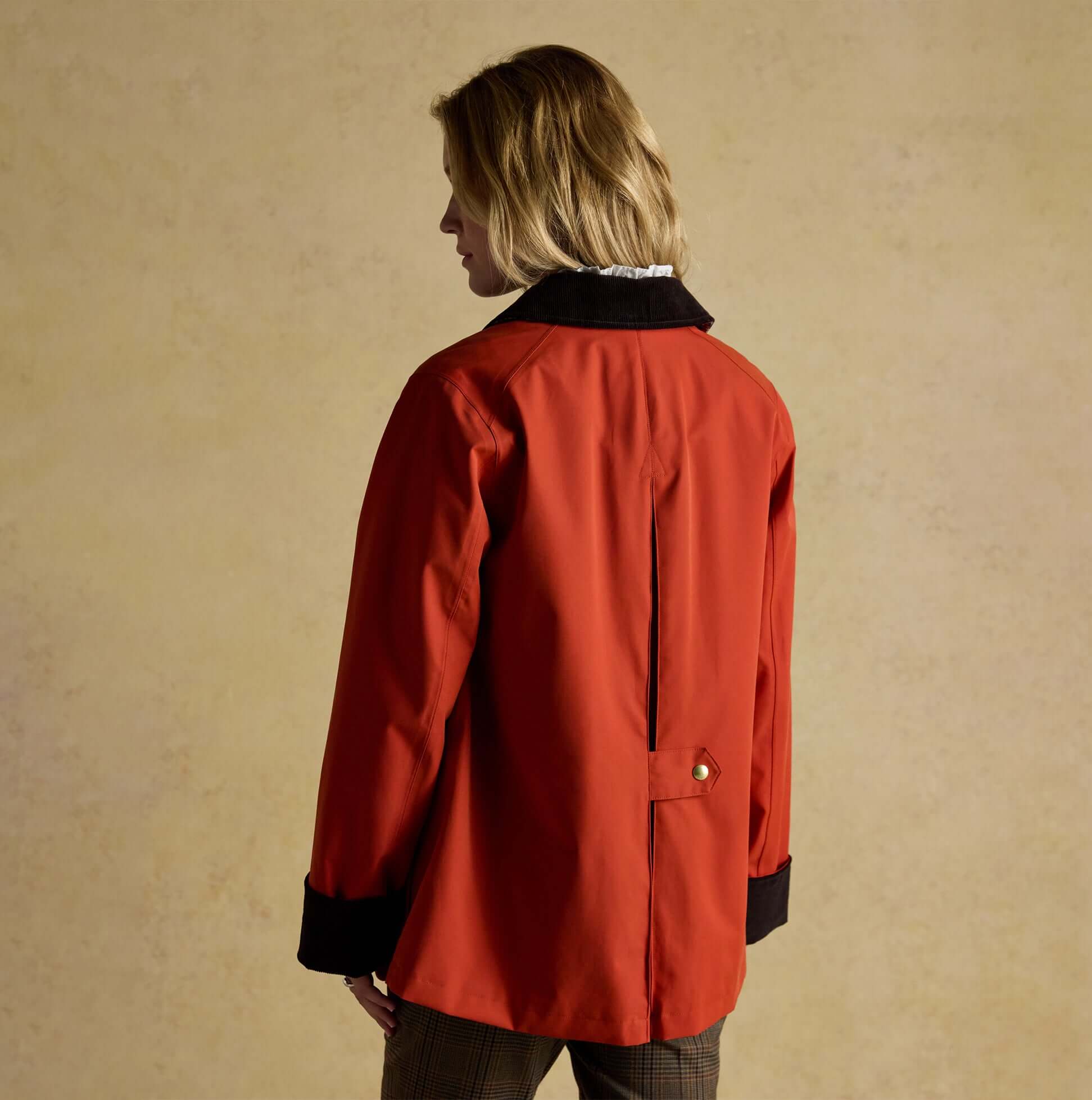 Joules KATHERINE Waterproof Heritage Coat Burnt Orange back view, featuring a button closure and contrasting black collar.