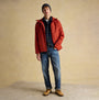 Joules HAMMOND Mens Beanie Grey worn by a man in a front view, paired with a red jacket and denim jeans.