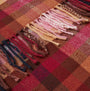 Joules LANGTREE Womens Winter Berry Red detail view of fabric texture and fringes in warm colors.