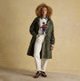Joules HOLKHAM Waterproof Packable Raincoat With Hood Green front view on model, styled with sweater and pants.