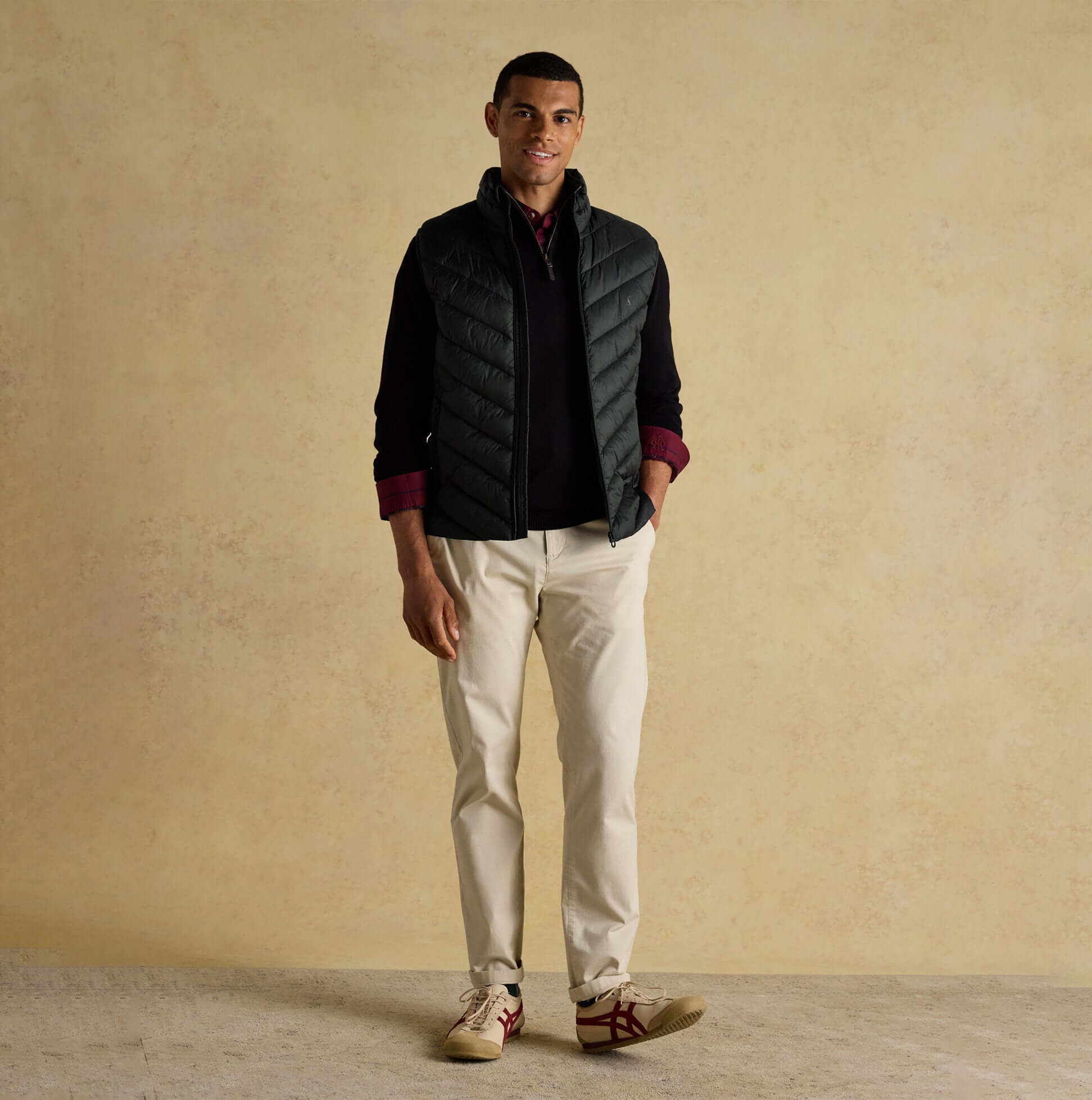 Joules GARRETT Mens Showerproof Padded Gilet Black front view worn over a sweater with light pants.